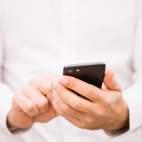 Person in white shirt using a smartphone.
