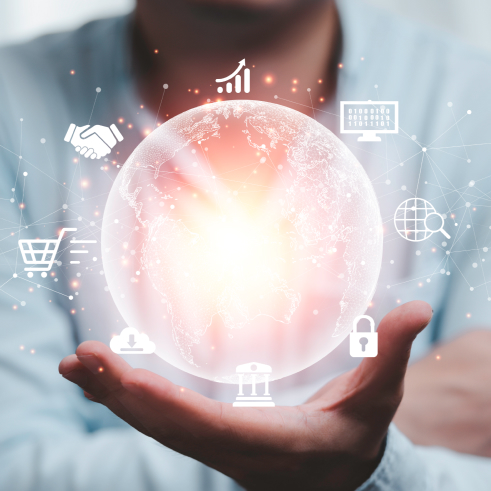 A person holding a glowing digital globe with various business and technology icons orbiting around it.